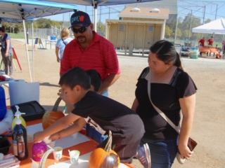 Busy pumpkin painting while Mom and Dad look on.