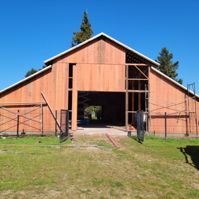 miller red barn, redwood siding, metal fence, scaffolding